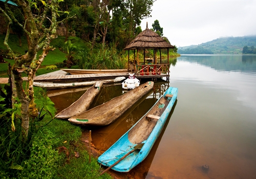 An exotic, hot non-specific destination with a brown river and some bright coloured boats.