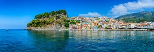 A view of Greece with coloured houses along a harbour that you might see on a Mediterranean cruise.